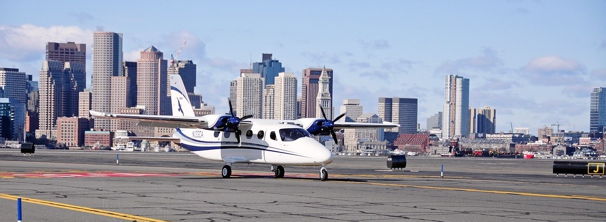 Cape Air Plane on Runway with city line behind it.